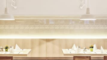 A restaurant with a clean, modern design featuring wooden furniture and white table settings.