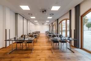 A conference room with long tables, chairs, and a large window.