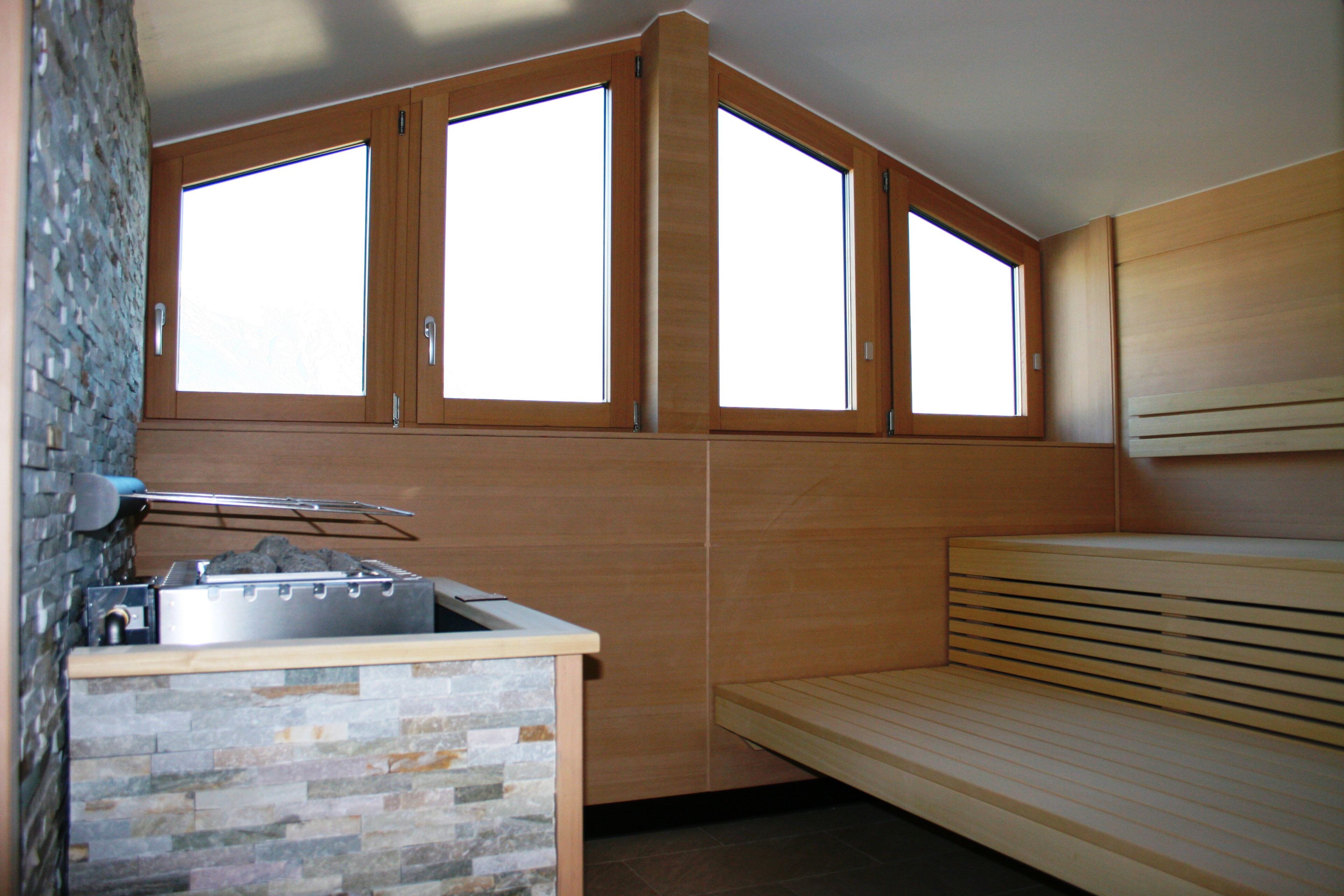 A compact kitchen with a stone backsplash, a built-in stove, and a wooden bench.