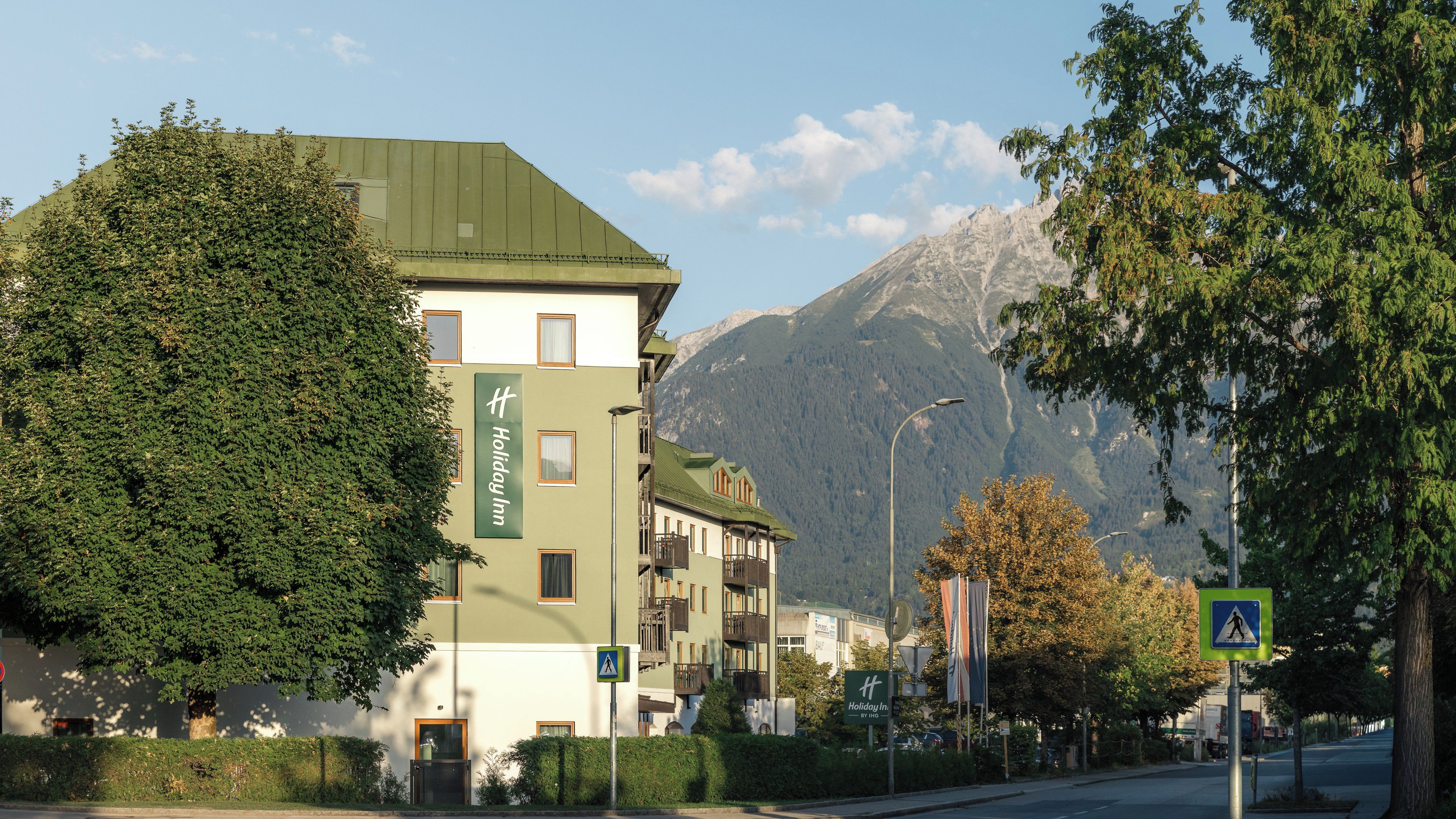 Un bâtiment d’hôtel doté d’un toit végétalisé, de nombreux balcons et offrant une vue sur les montagnes.