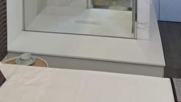 Habitación Deluxe doble, balcón, vistas parciales al mar | Baño | Ducha, artículos de higiene personal gratuitos y secador de pelo