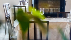 Una taula de dinar amb cadires i dues copes de vi.