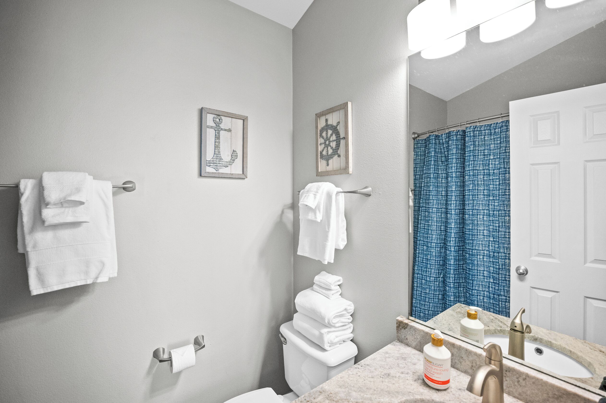 A bathroom with a toilet, sink, and a shower curtain.