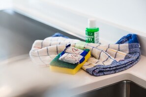 A kitchen sink with a cloth, sponge, and cleaning spray. - {Suite 513} Gym, Business Room, Modern, Relax (Lugano)