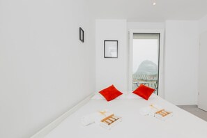 A minimalist hotel room with a large window, white walls, and a view of buildings. - {Suite 513} Gym, Business Room, Modern, Relax (Lugano)