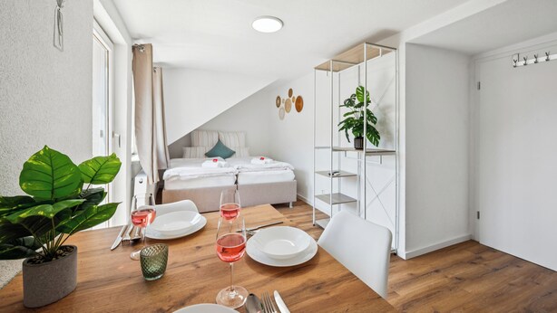 Ein modernes Schlafzimmer mit einem Bett, einem Nachttisch und einer kleinen Sitzecke.