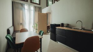 Eine kleine Küche mit Essbereich, Spüle und Kühlschrank.
