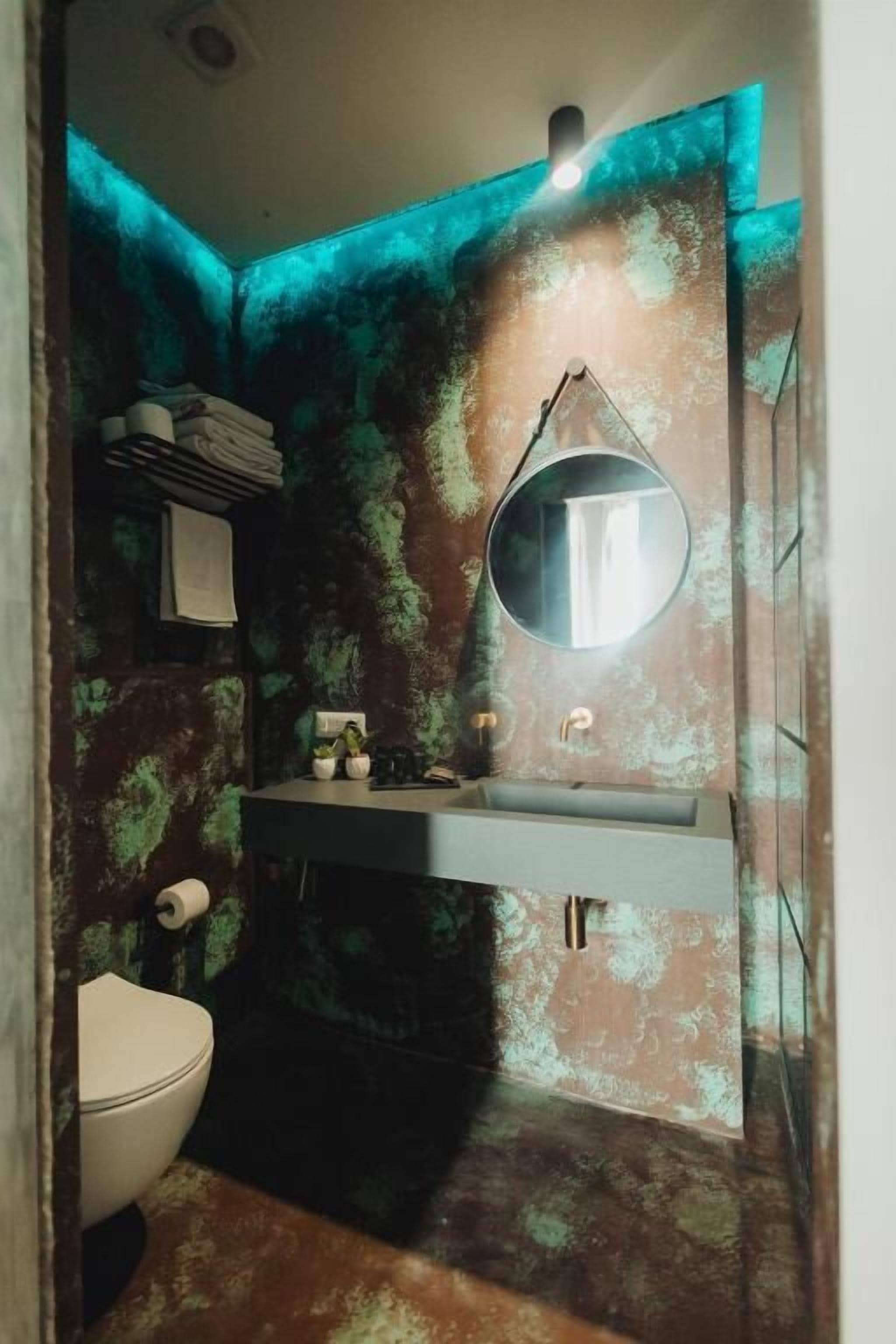 Un baño con lavamanos, espejo e inodoro.