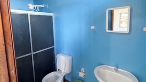Ein Badezimmer mit Toilette, Waschbecken und einem Spiegel an der Wand.