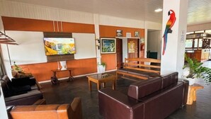 Eine Lobby mit Sitzgelegenheit, einem Fernseher und einem Wandbild.