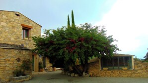 Un edificio de piedra con camino de grava, una ventana pequeña y una puerta.