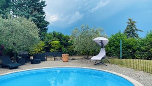 Una piscina con sillas de descanso y una zona de terraza.