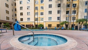 Una piscina de diseño circular, rodeada por un patio de ladrillo.