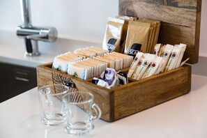 A wooden box with tea bags and empty glasses on a countertop. - {Suite 514} Gym, Business Room, Modern, Relax (Lugano)