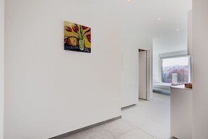 A modern interior with a minimalist design, a large window with a city view, and a single piece of artwork on the wall. - {Suite 514} Gym, Business Room, Modern, Relax (Lugano)