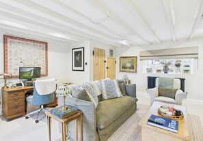 A living room with a sofa, a desk, a chair, and a coffee table. - Cosy 3-bed cottage in sought after village Freshford. Stunning views of valley. (Freshford)