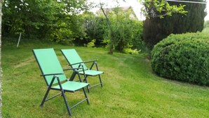 A grassy area with two green lawn chairs.