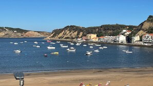 A coastal town with boats on the water, buildings along the shore, and a clear sky. - Duplex Apartment with Panoramic Views of the Beach at São Martinho do Porto (São Martinho do Porto)