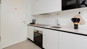 Una cucina moderna con mobili bianchi, un forno a microonde Bosch, un lavello e un forno.