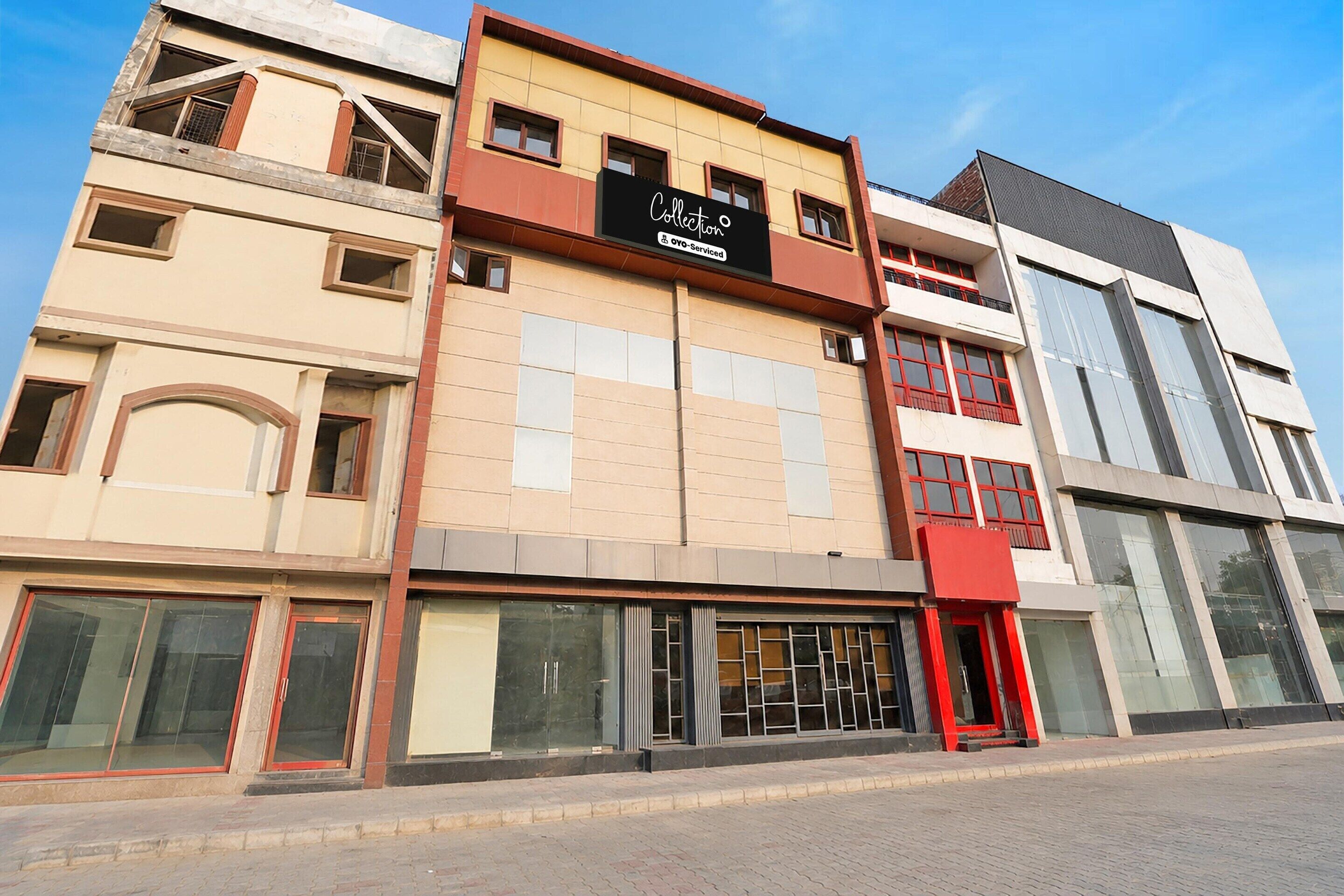 A multi-story building with a commercial ground floor featuring large windows and a red awning.