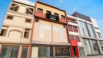 A multi-story building with a commercial ground floor featuring large windows and a red awning.