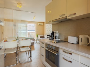 A modern kitchen with a dining area, stainless steel appliances, and a view to the outside. - Apartment Patti by Interhome (Siofok)