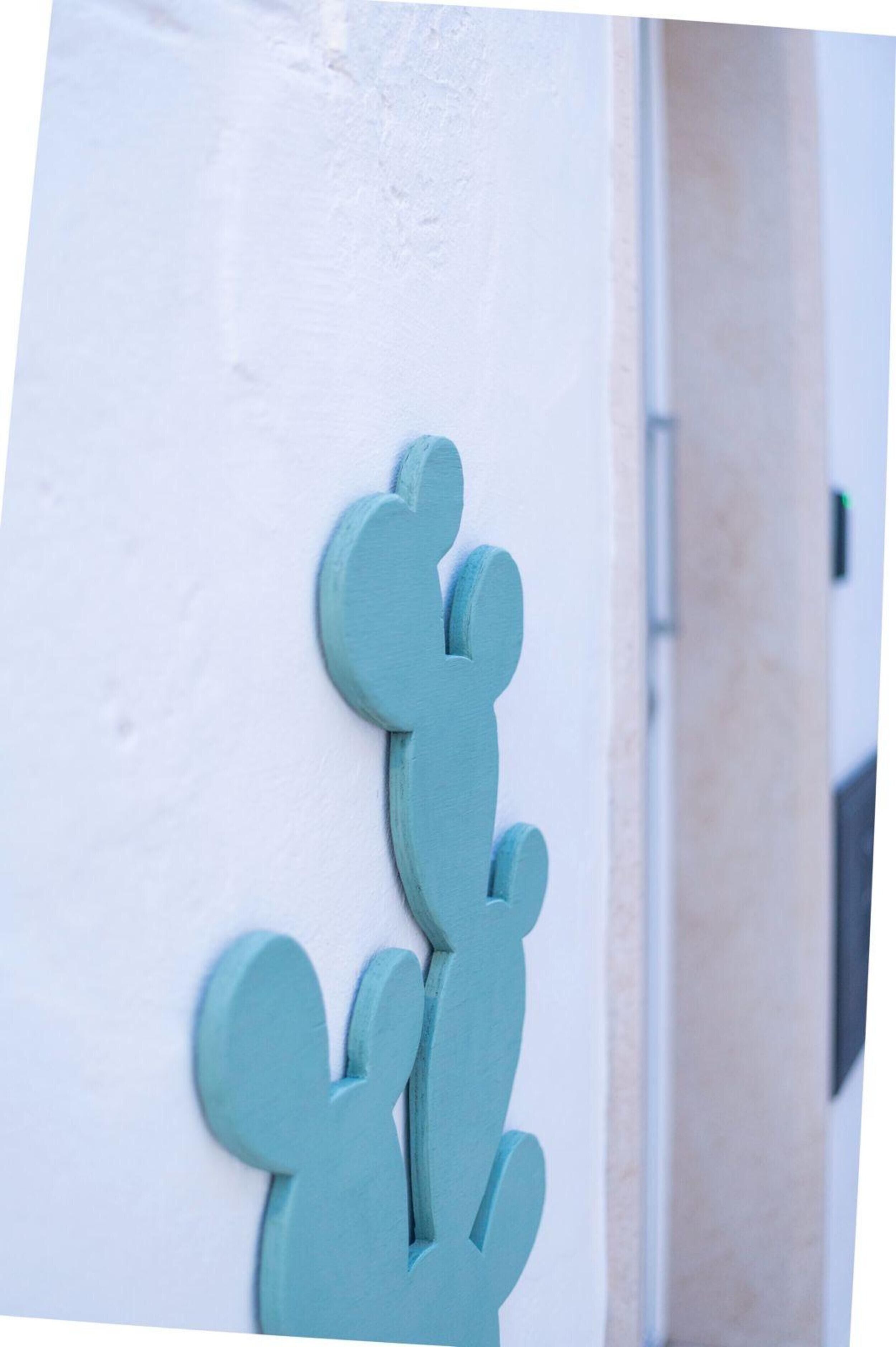 A wall with a cactus decoration.