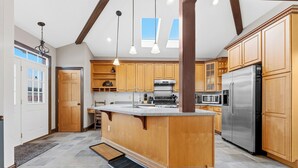 Une cuisine avec des meubles en bois, un réfrigérateur en acier inoxydable et un îlot central.