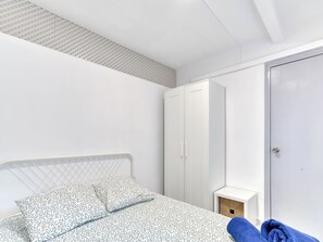A bedroom with a bed, a wardrobe, and a small wooden box. - Apartment Cannes by Interhome (Playa de Aro)