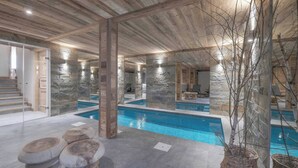 A modern indoor pool with stone walls and wooden beams, a staircase, and a seating area with stone stools. - Exceptional Chalet With Pool A/C 10P - Megeve (Megeve)