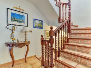 A staircase with ornate wooden balusters and a patterned tile floor. - Quietud by Interhome (Sta Cristina d'Aro)