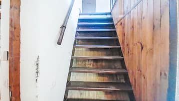Una scala in legno con corrimano che conduce a una porta in cima.