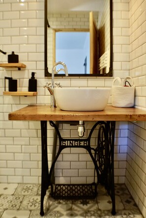 A bathroom with a white sink, black metal legs, and a mirror above it.