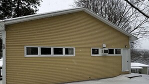 A single-story building with a gabled roof and a garage door.