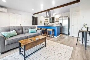 A modern living room with a sofa, coffee table, and kitchen area with bar stools. - Uncork & Unwind in Paso Robles Wine Country (Paso Robles)