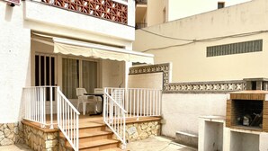 A building with a stone staircase, a covered outdoor seating area, and a barbecue grill. - CASA MARGARIDA - LÈSCALA - 20 meters from Riells Beach, with parking and a barbecue (L'Escala)