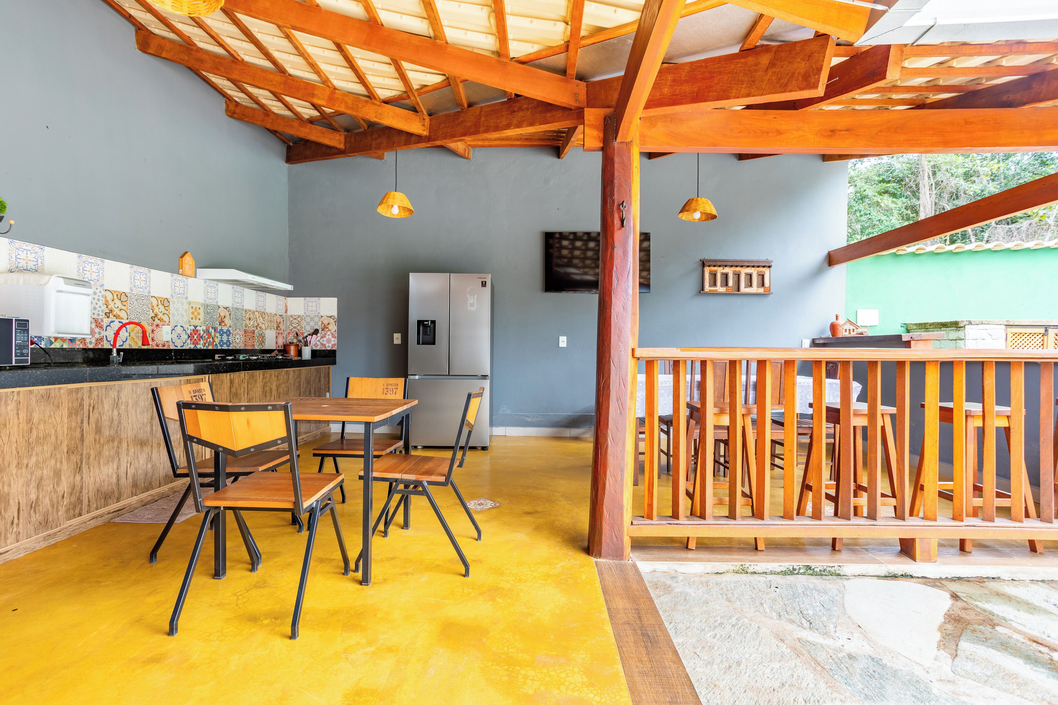 Un restaurant avec un sol jaune, des poutres en bois au plafond et un comptoir avec des chaises.