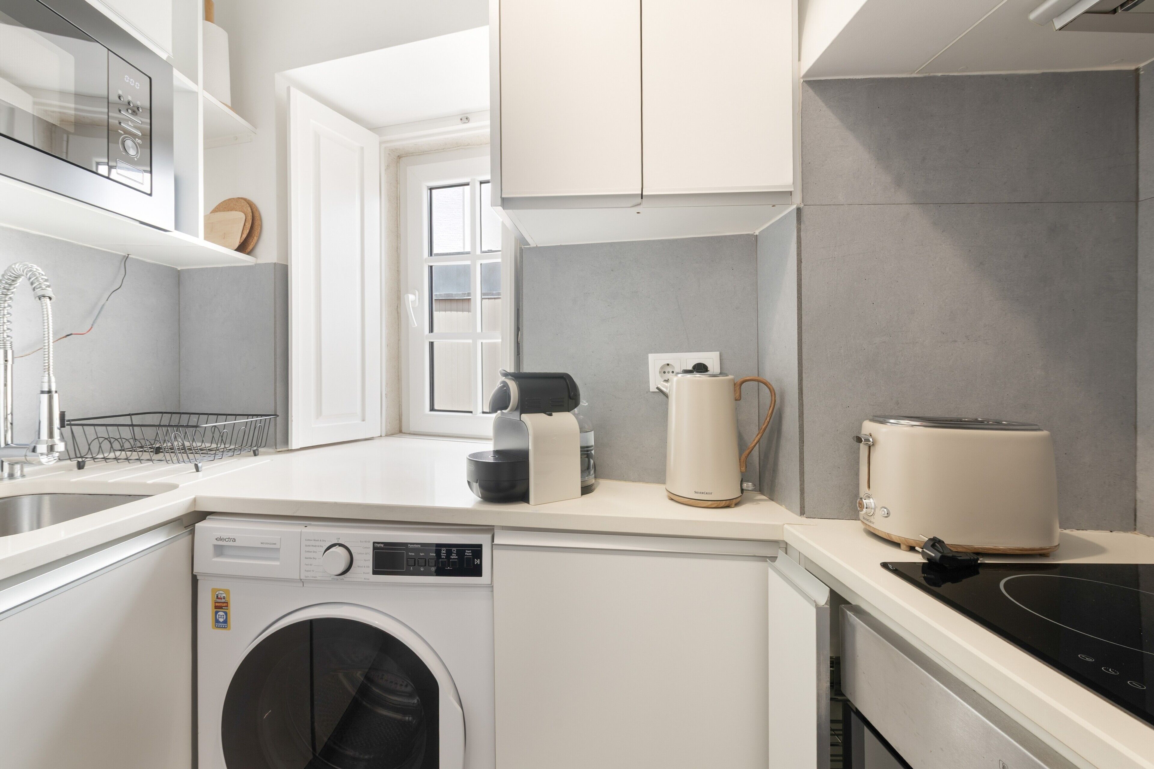 A modern kitchen with a built-in washing machine, a coffee maker, and a toaster.