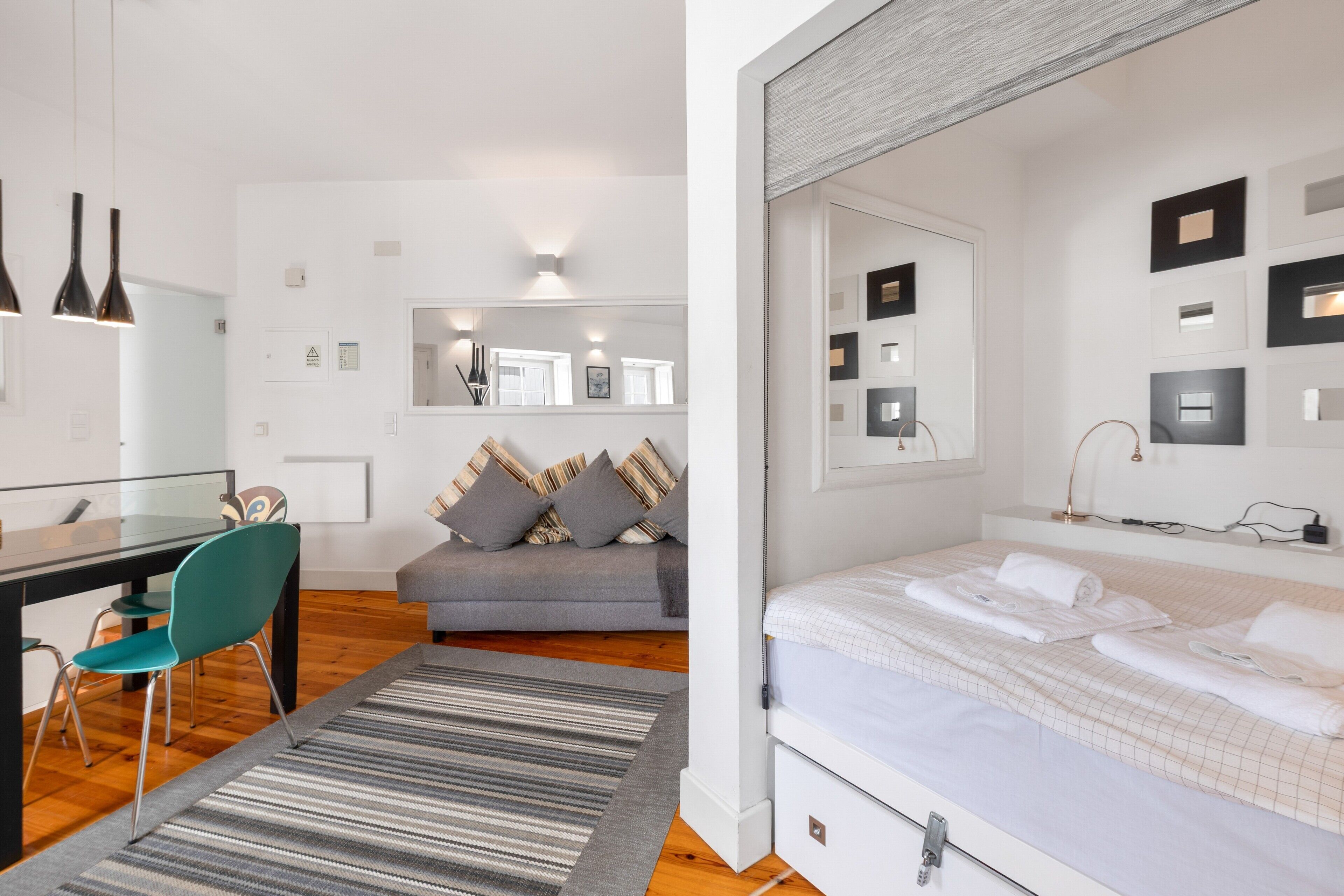 Une chambre à coucher moderne avec un lit, une table de chevet et un miroir.