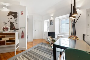 A modern living room with a dining area, a large window, and a minimalist design. - Madragoa Boutique Studio (Lisbon)