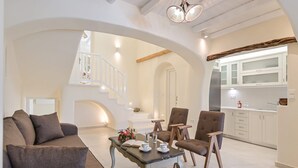A spacious living area with a sofa, chairs, a coffee table, and a staircase leading to an upper level. - Villa Calivion, Private Outdoor Hot Tub, Furnished Terrace, Shared Pool, Naxos (Naxos)