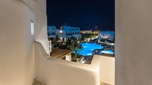 A nighttime view of a pool area with multiple pools, surrounded by white buildings with blue lighting. - Villa Calivion, Private Outdoor Hot Tub, Furnished Terrace, Shared Pool, Naxos (Naxos)