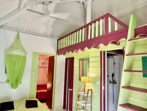 A room with a bed, a small table with a lamp, a shower, and a balcony with a railing. - Datura – Locs-Guadeloupe.com Creole charm in Sainte-Anne – Near the beach – Sleeps 4–6 (Sainte-Anne)