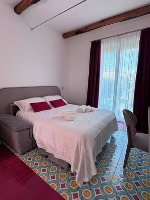 A hotel room with a bed, a sofa, a chair, and a window with curtains. - Relais Totò:vacation home with authentic charm, inspired by  Naples (Campania)