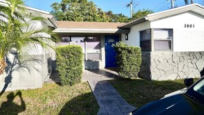 A residential property with a garage, a blue door, and a stone wall.