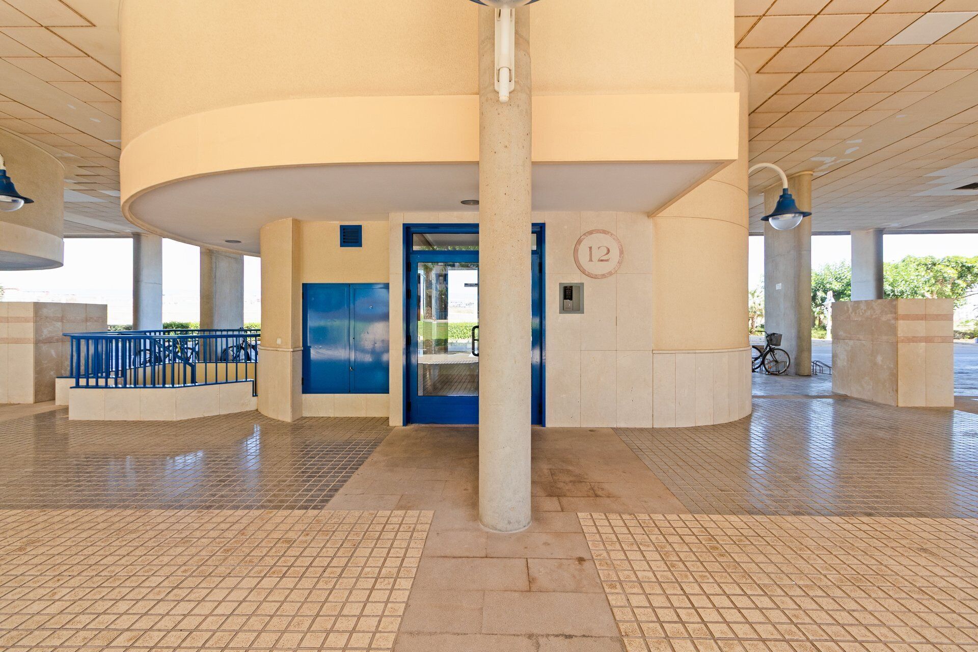Un vaste espace intérieur doté d’un plafond incurvé, d’une porte bleue et d’un chiffre « 12 » bien visible sur le mur.