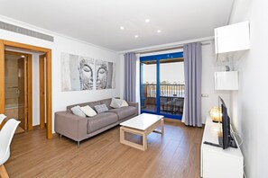 A modern living room with a sofa, coffee table, and artwork on the wall. - GuestReady - Beachside apartment with Pool (Alboraya)