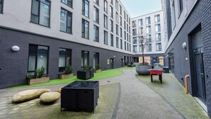 A courtyard with a seating area, planters, and a table. - Student Only Howard Gardens (Cardiff)