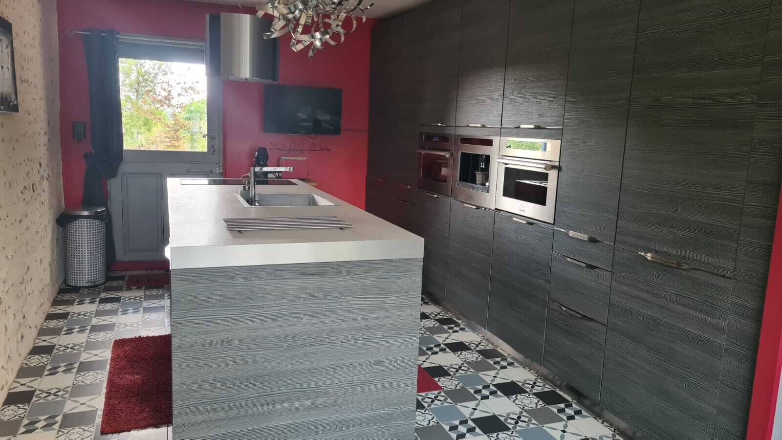 A modern kitchen with a central island, built-in appliances, and a patterned floor.