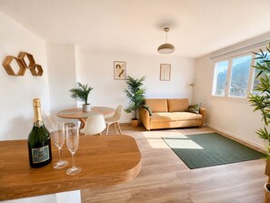 Ein modernes Wohnzimmer mit einem Holzesstisch, einer Couch und einem großen Fenster.